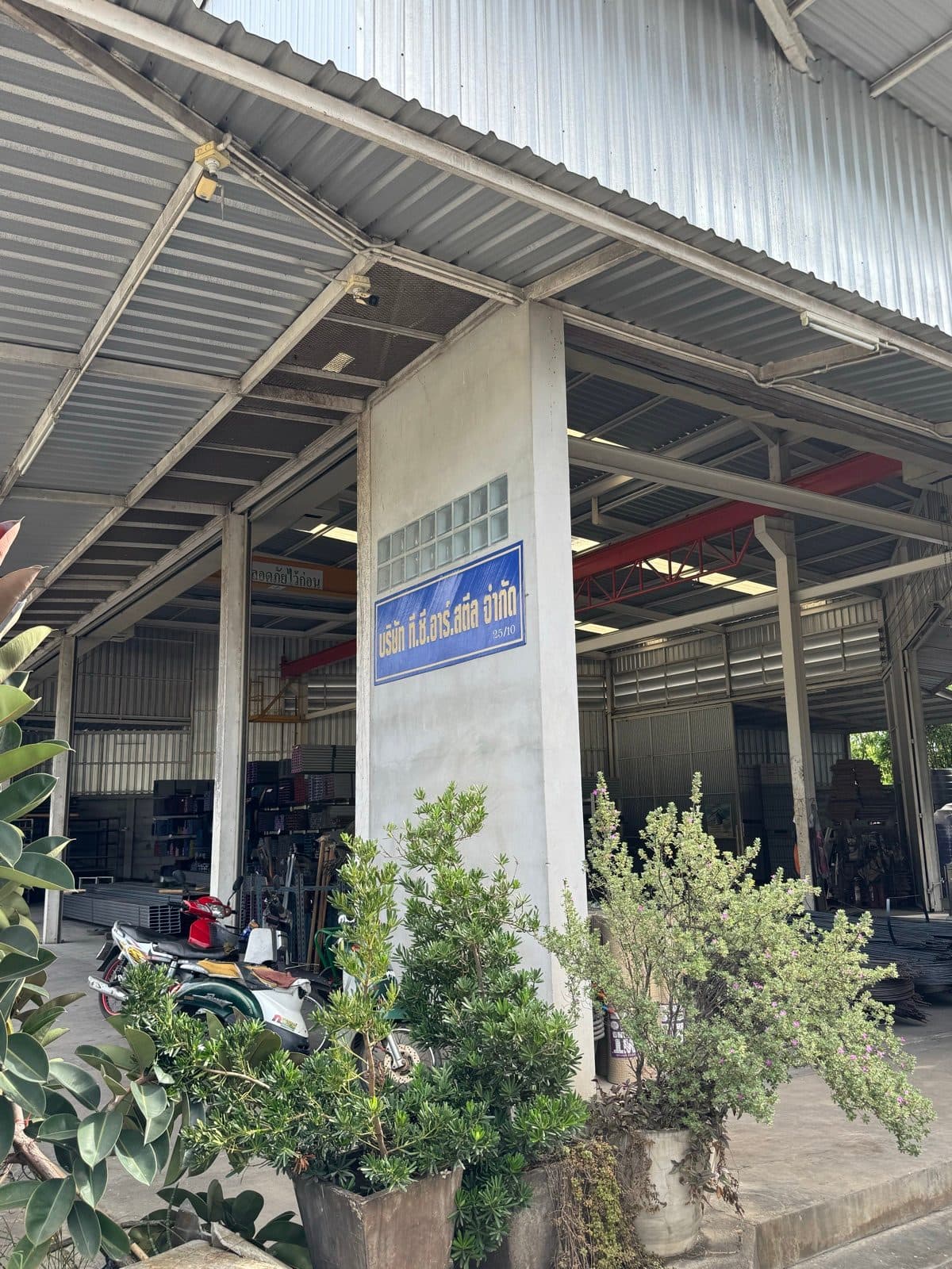 ป้ายบริษัท ที.ซี.อาร์.สตีล จำกัด หน้าคลังสินค้า ร้านเหล็กพนัสนิคม ชลบุรี